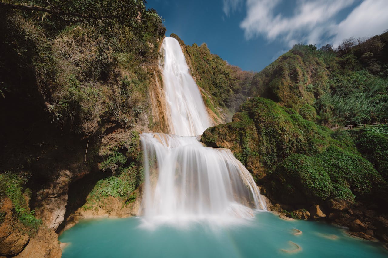 Stunning waterfall cascading over lush green cliffs in Chiapas, Mexico.