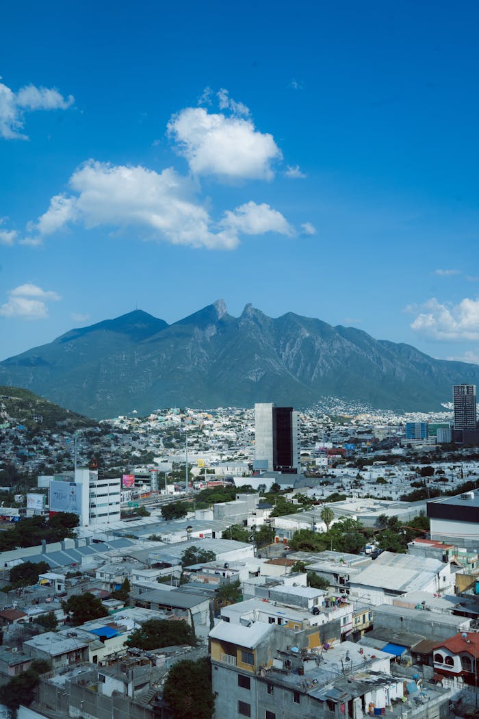 gallery-02 A vibrant cityscape view of Monterrey with the Cerro de la Silla in the background under a clear blue sky.